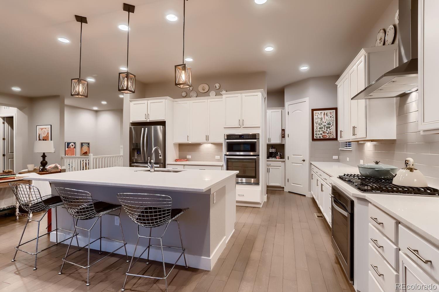 9452 Gore Loop Arvada, CO 80007 - Photo 11 of 30 a kitchen with stainless steel appliances kitchen island granite countertop a stove a sink a oven a dining table and chairs