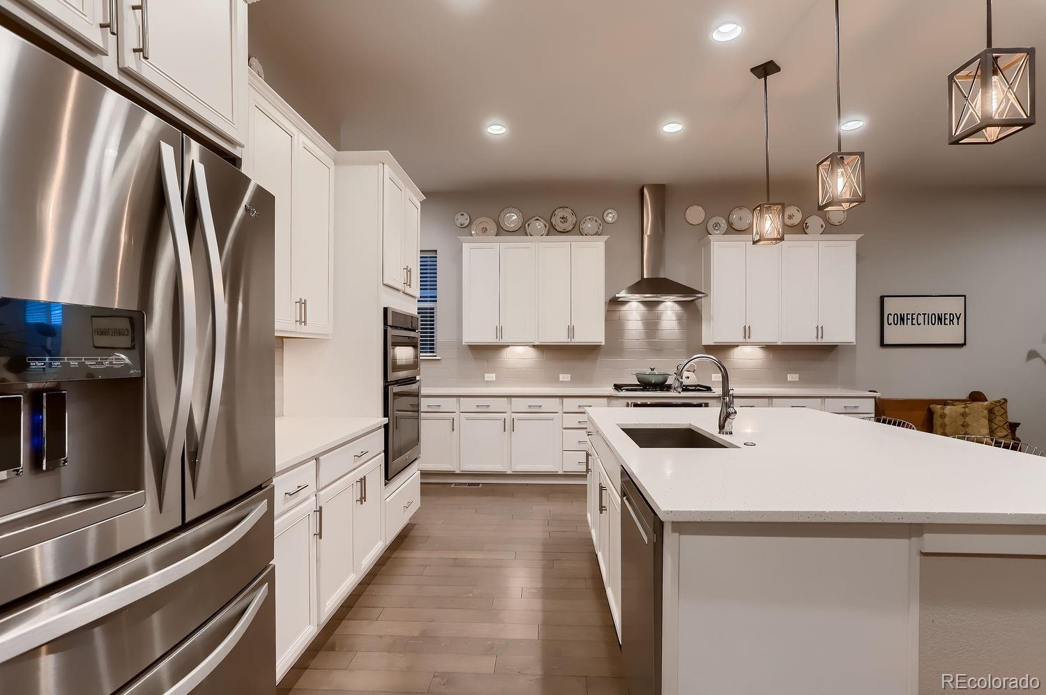 9452 Gore Loop Arvada, CO 80007 - Photo 13 of 30 a kitchen with stainless steel appliances a sink stove and refrigerator