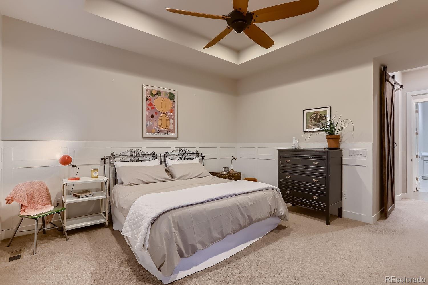 9452 Gore Loop Arvada, CO 80007 - Photo 17 of 30 a spacious bedroom with a bed and a chandelier