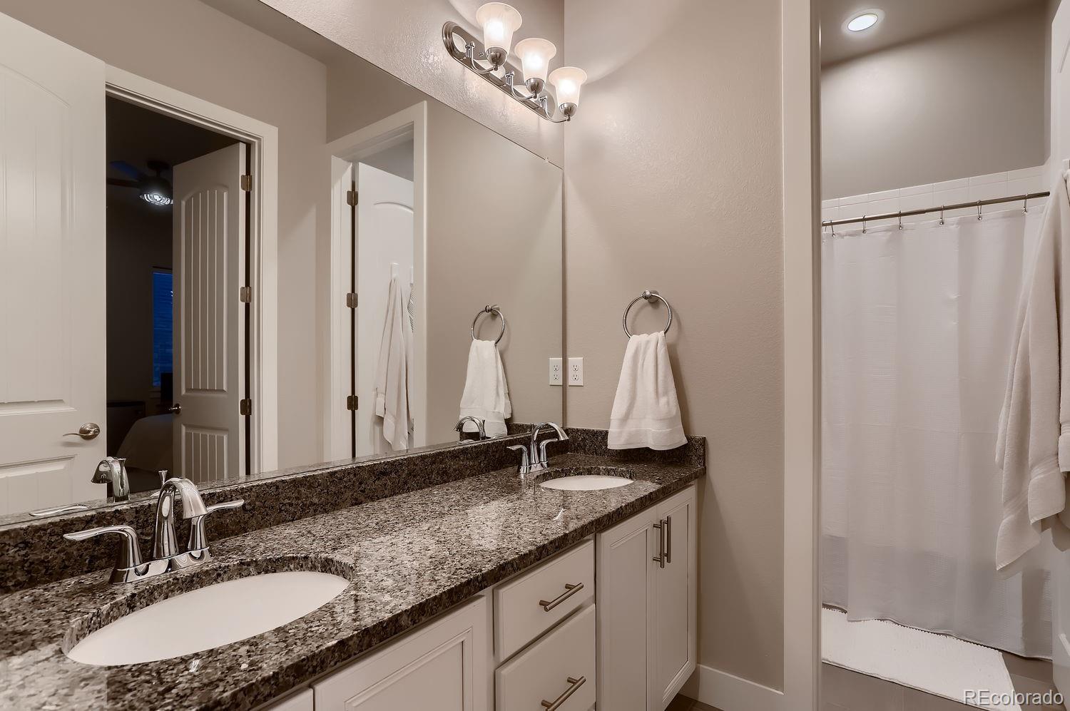 9452 Gore Loop Arvada, CO 80007 - Photo 22 of 30 a bathroom with a granite countertop sink and a mirror