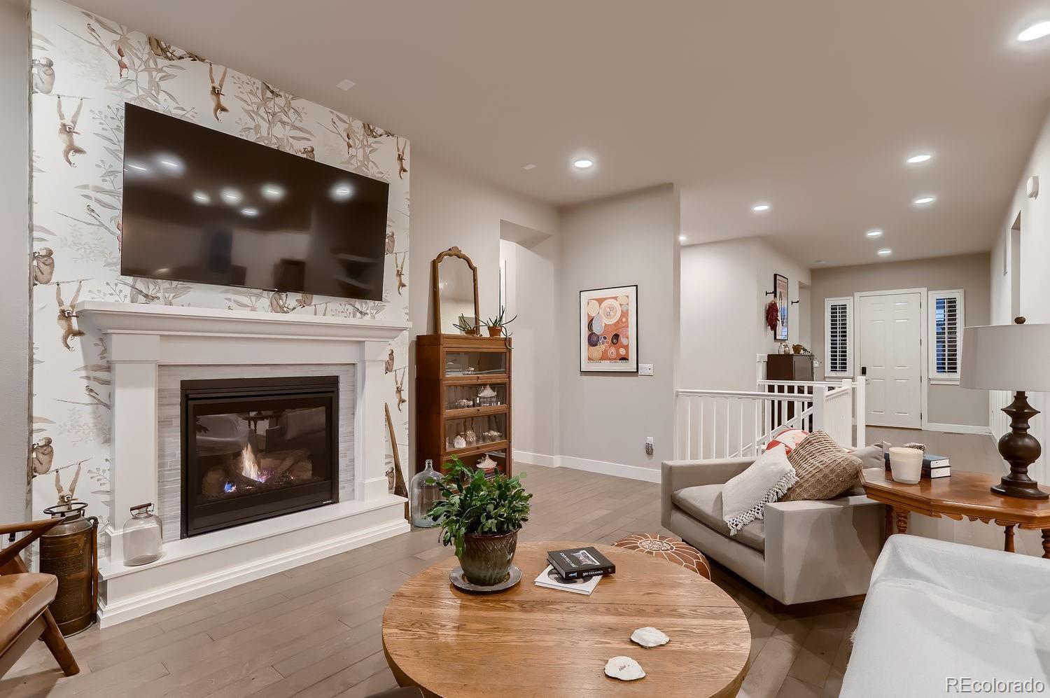 9452 Gore Loop Arvada, CO 80007 - Photo 8 of 30 a living room with furniture a flat screen tv and a fireplace