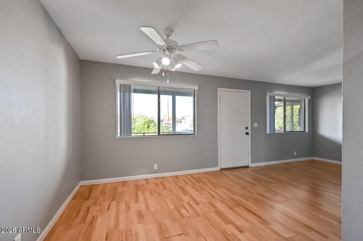 1702 West Tuckey Lane, Unit 212 Phoenix, AZ 85015 - Photo 12 of 20 a view of an empty room with window and wooden floor