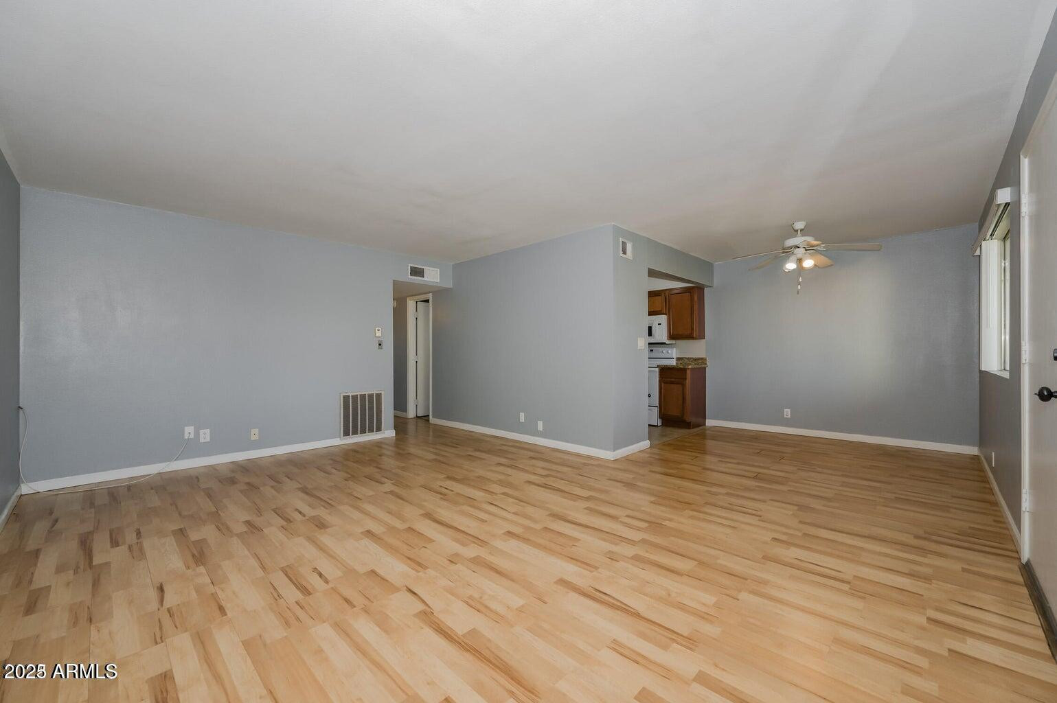 1702 West Tuckey Lane, Unit 212 Phoenix, AZ 85015 - Photo 13 of 20 a view of an empty room with wooden floor and a window