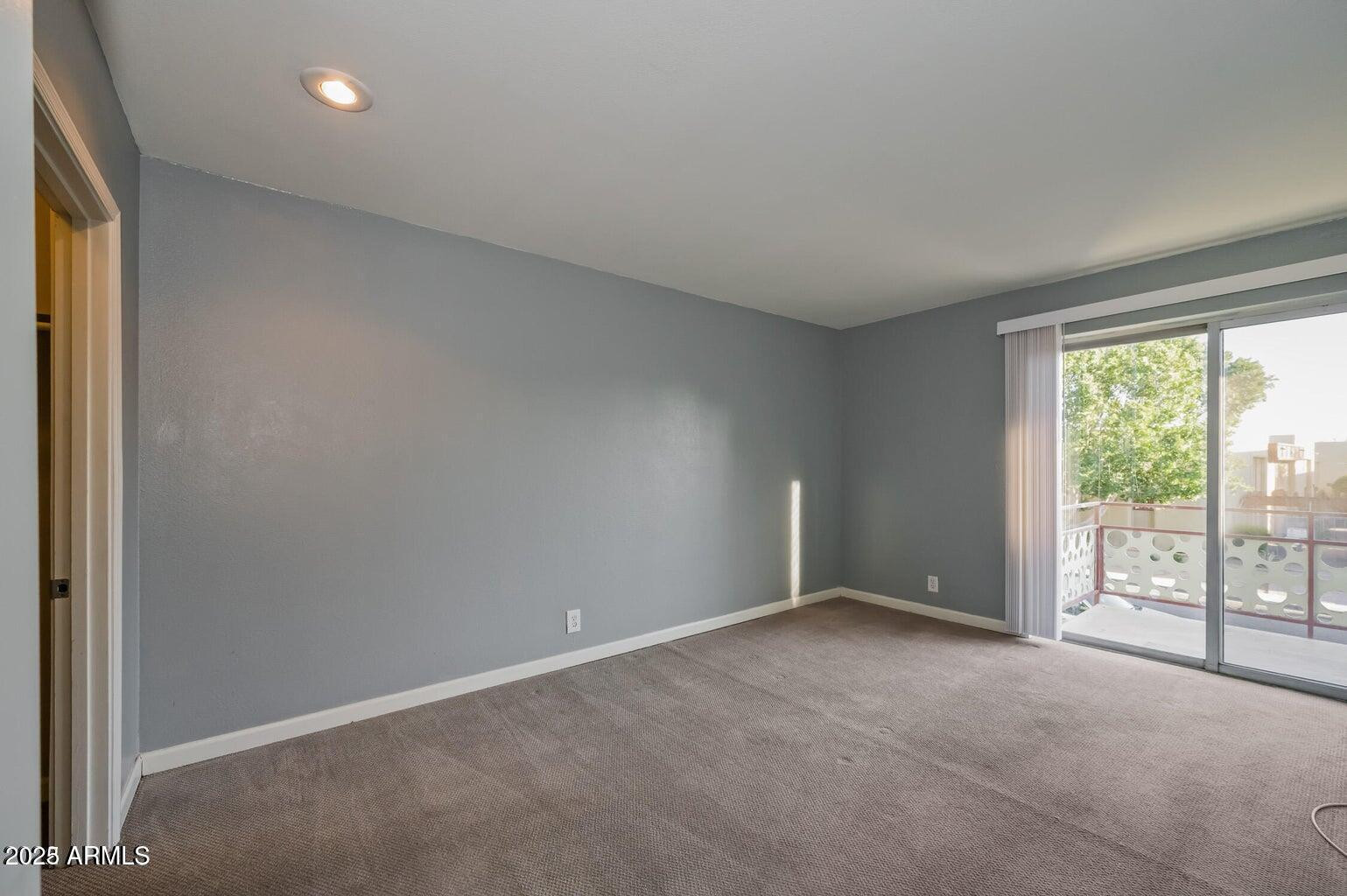 1702 West Tuckey Lane, Unit 212 Phoenix, AZ 85015 - Photo 16 of 20 an empty room with windows and city view