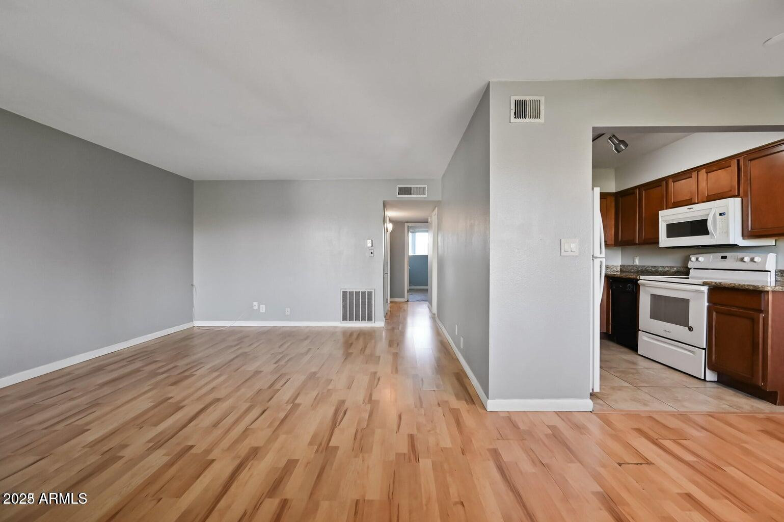 1702 West Tuckey Lane, Unit 212 Phoenix, AZ 85015 - Photo 7 of 20 a view of a kitchen with wooden floor and electronic appliances
