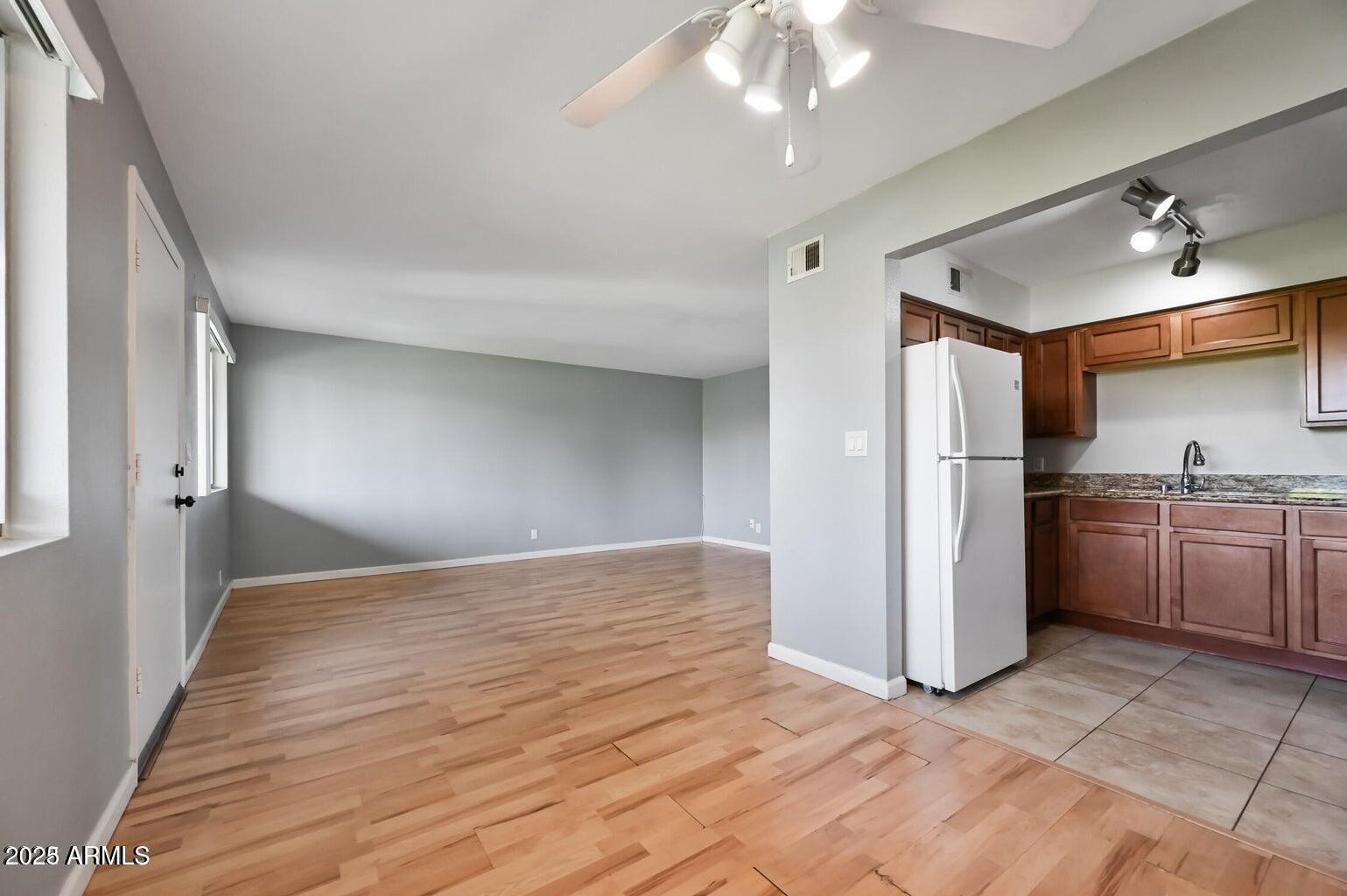 1702 West Tuckey Lane, Unit 212 Phoenix, AZ 85015 - Photo 9 of 20 a view of a kitchen with a sink and dishwasher a refrigerator with wooden floor