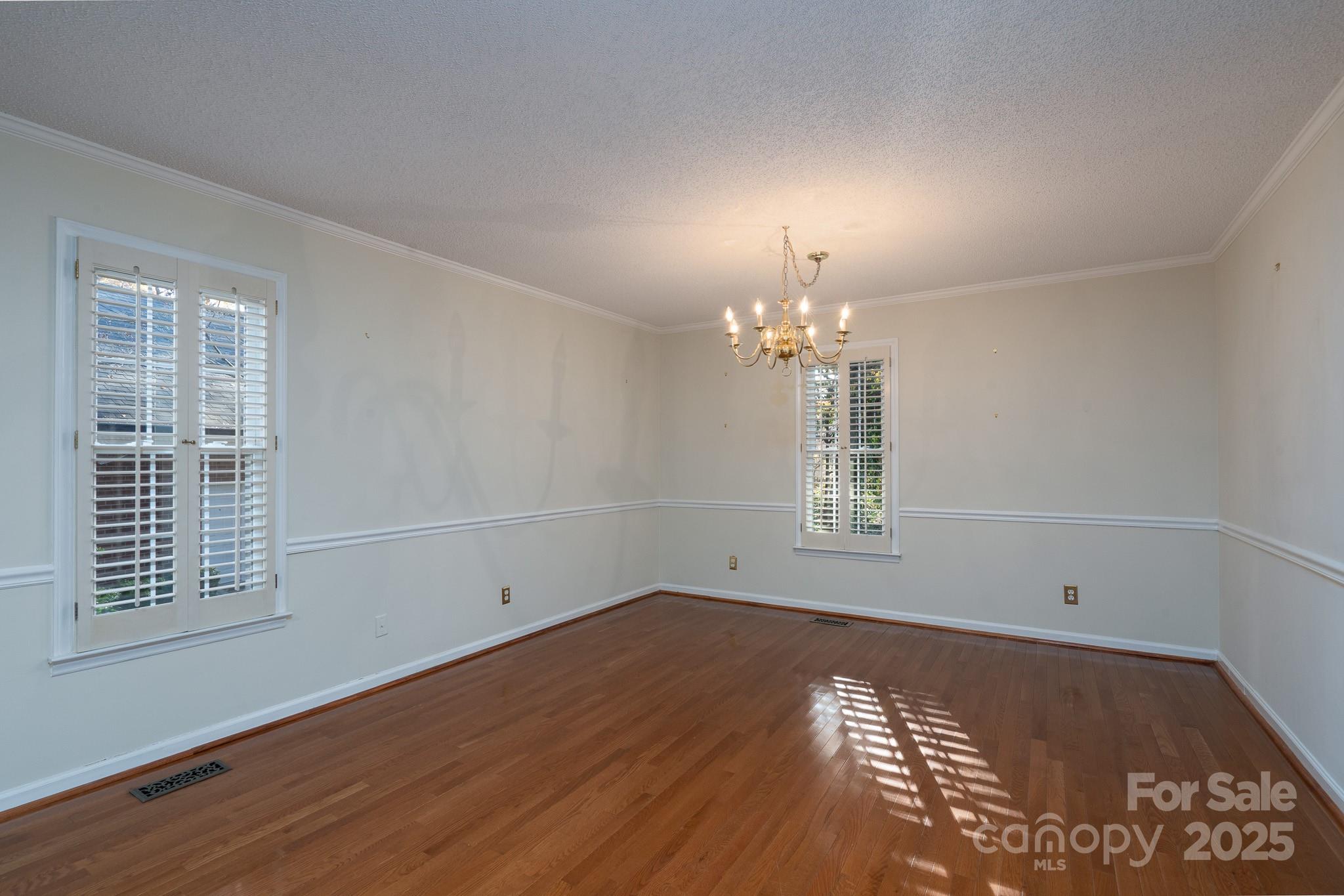 621 Peacehaven Road Kannapolis, NC 28083 - Photo 34 of 44 an empty room with wooden floor chandelier and windows