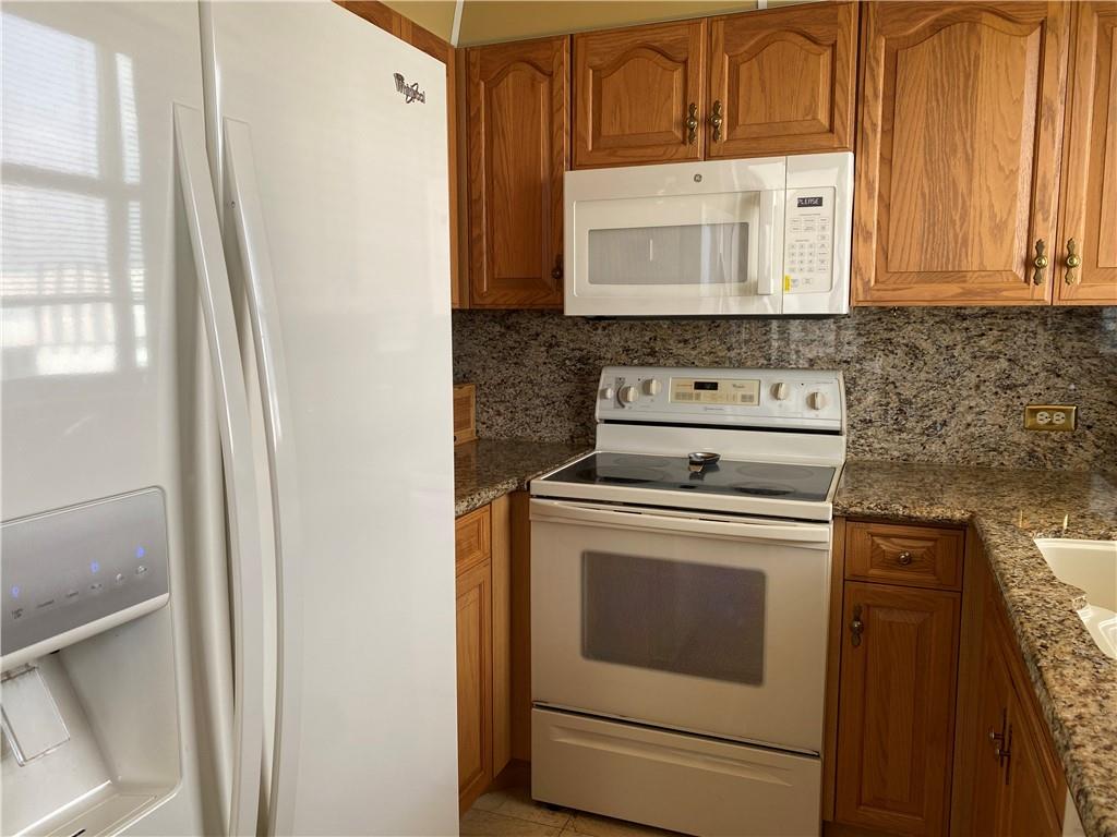 1010 South Ocean Boulevard, Unit PH12 Pompano Beach, FL 33062 - Photo 15 of 47 a kitchen with a stove microwave and sink