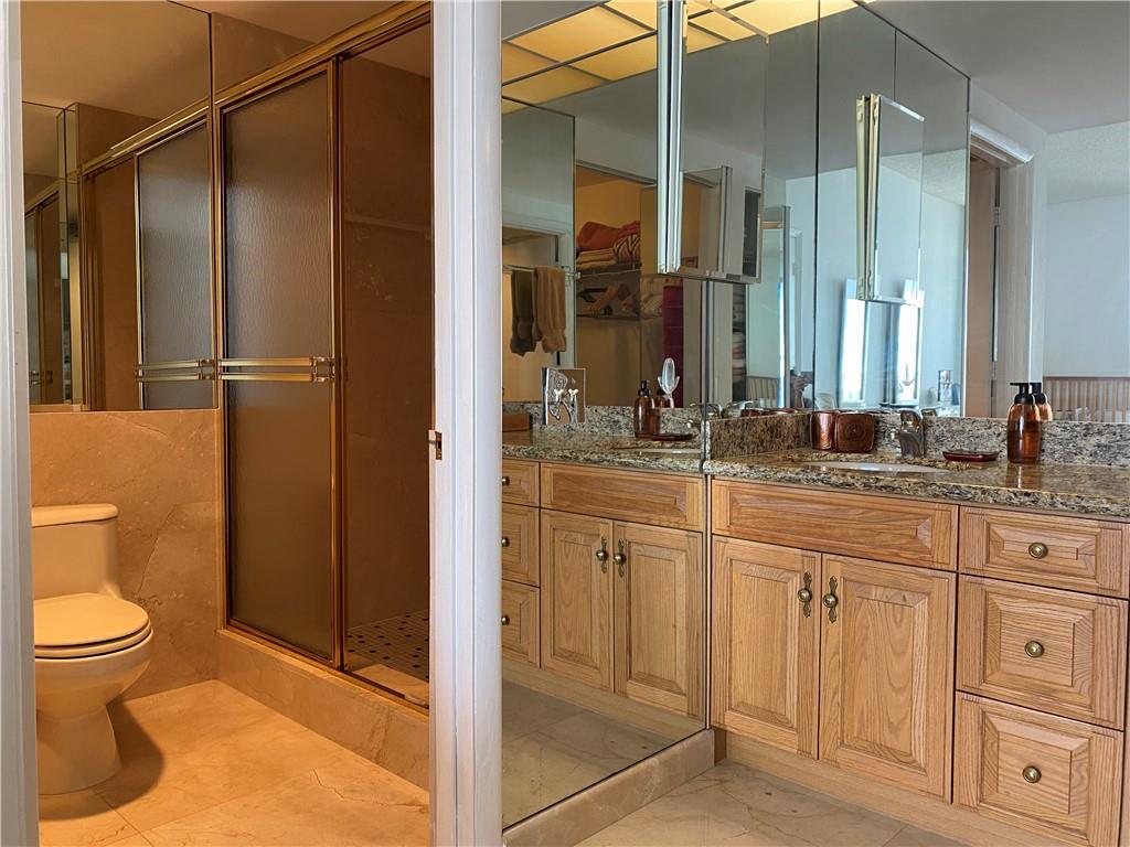 1010 South Ocean Boulevard, Unit PH12 Pompano Beach, FL 33062 - Photo 21 of 47 a bathroom with a granite countertop sink toilet and shower