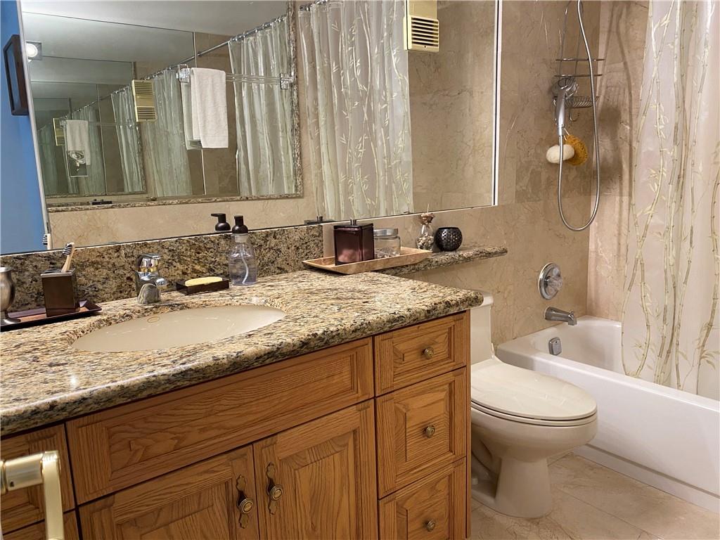 1010 South Ocean Boulevard, Unit PH12 Pompano Beach, FL 33062 - Photo 26 of 47 a bathroom with a granite countertop sink a toilet and a bathtub