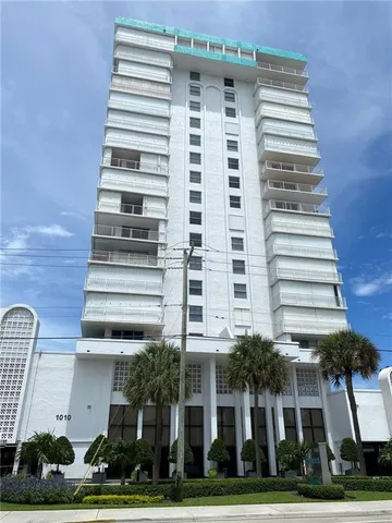 a view of a balcony with floor to ceiling window and palm tree