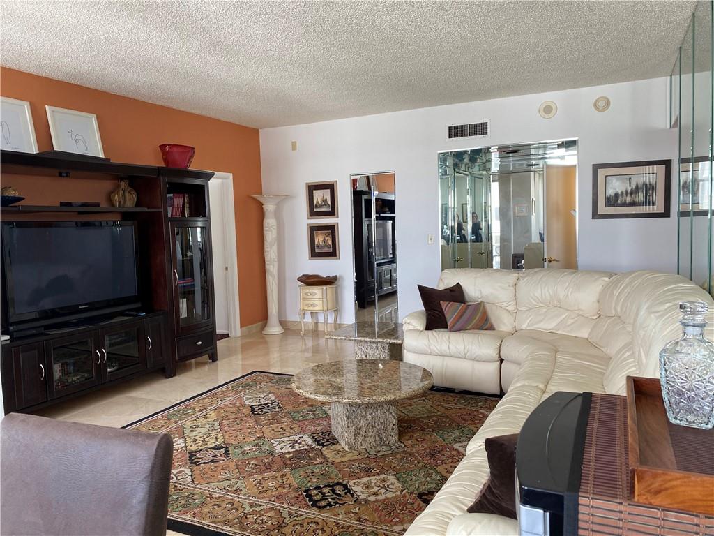 1010 South Ocean Boulevard, Unit PH12 Pompano Beach, FL 33062 - Photo 7 of 47 a living room with furniture and a flat screen tv