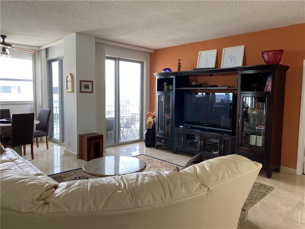 1010 South Ocean Boulevard, Unit PH12 Pompano Beach, FL 33062 - Photo 9 of 47 a living room with furniture a flat screen tv and a fireplace