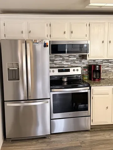 a view of a hallway with wooden floor and cabinet