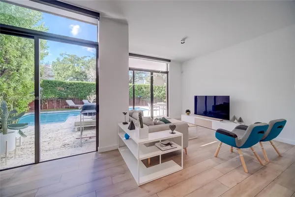 a view of a big room with wooden floor and windows
