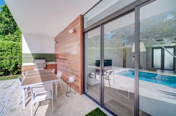 a view of house with swimming pool and furniture