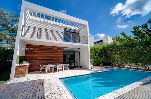 a view of a house with pool and chairs