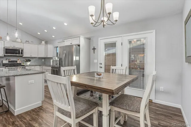 a living room with fireplace a flat screen tv and kitchen view