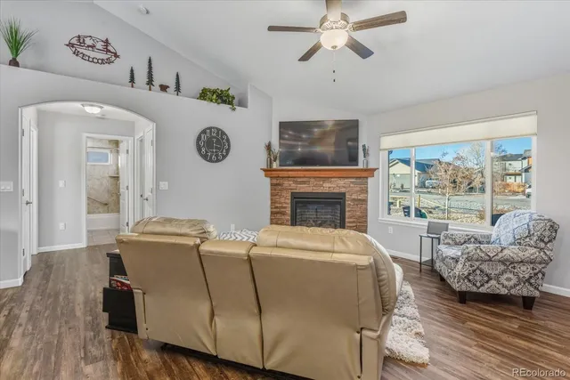 a living room with furniture and a dining table with wooden floor