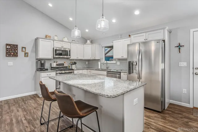 a kitchen with stainless steel appliances granite countertop a stove a sink and a microwave
