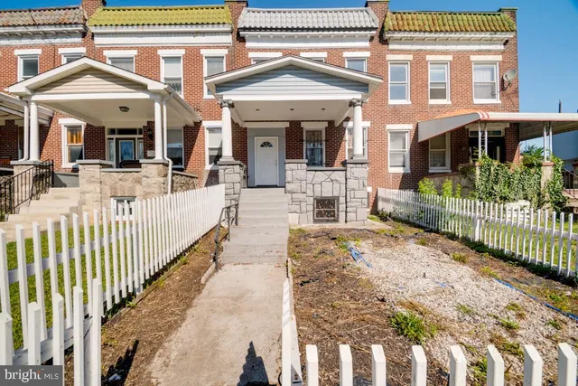 a view of a house with wooden fence