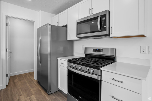 2194 Wolverine Way, Unit 2531 Washington, UT 84780 - Photo 12 of 52 Kitchen featuring stainless steel appliances, white cabinetry, solid surface countertops, and wood-finish flooring