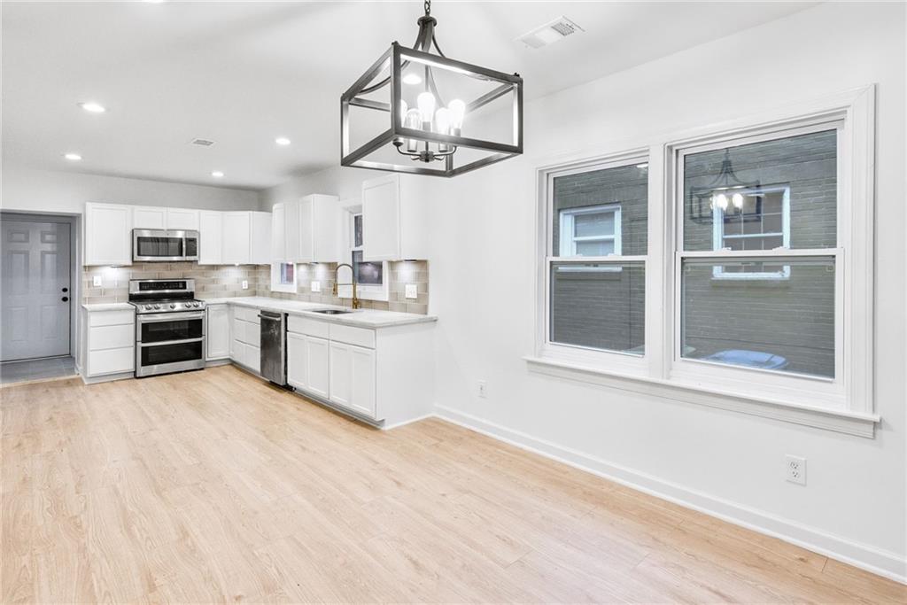 1967 Browns Mill Road Southeast Atlanta, GA 30315 - Photo 11 of 35 a kitchen with stainless steel appliances granite countertop a stove and cabinets
