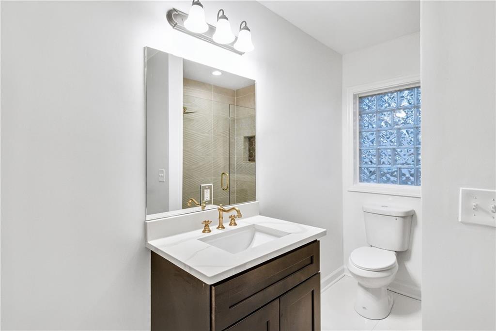 1967 Browns Mill Road Southeast Atlanta, GA 30315 - Photo 18 of 35 a bathroom with a toilet a sink a mirror and a window