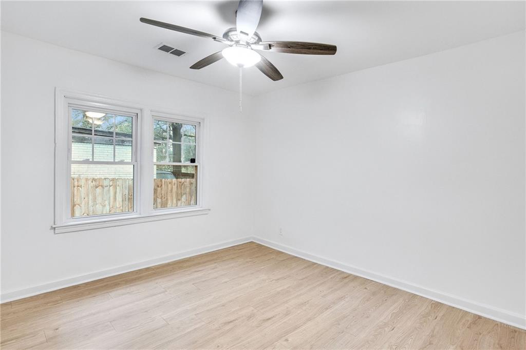 1967 Browns Mill Road Southeast Atlanta, GA 30315 - Photo 21 of 35 an empty room with wooden floor fan and windows