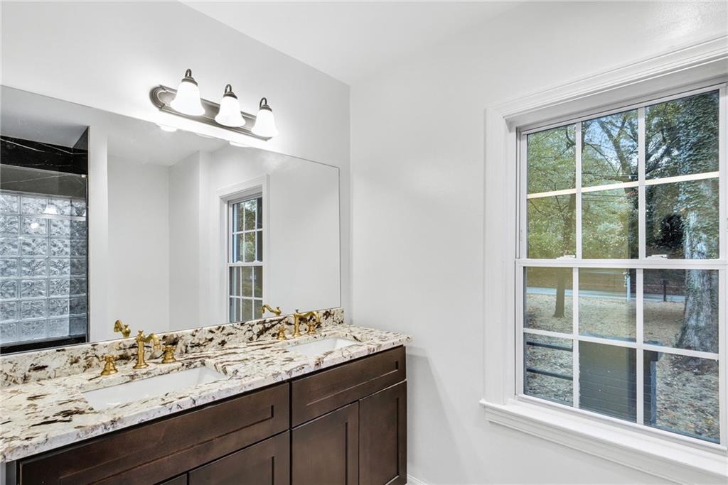 1967 Browns Mill Road Southeast Atlanta, GA 30315 - Photo 23 of 35 a bathroom with a granite countertop sink and a large mirror