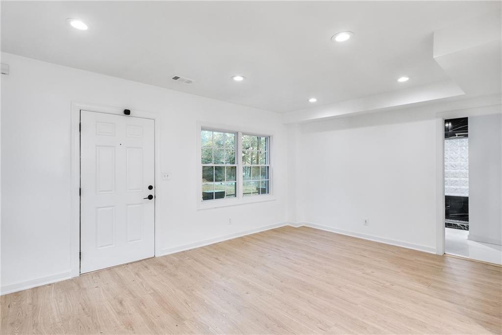1967 Browns Mill Road Southeast Atlanta, GA 30315 - Photo 9 of 35 a view of an empty room with wooden floor and a window