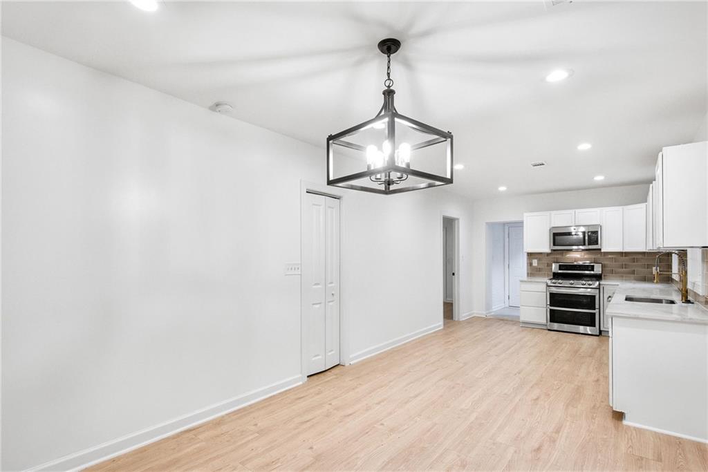 1967 Browns Mill Road Southeast Atlanta, GA 30315 - Photo 10 of 35 a view of kitchen with stainless steel appliances wooden floor and stove
