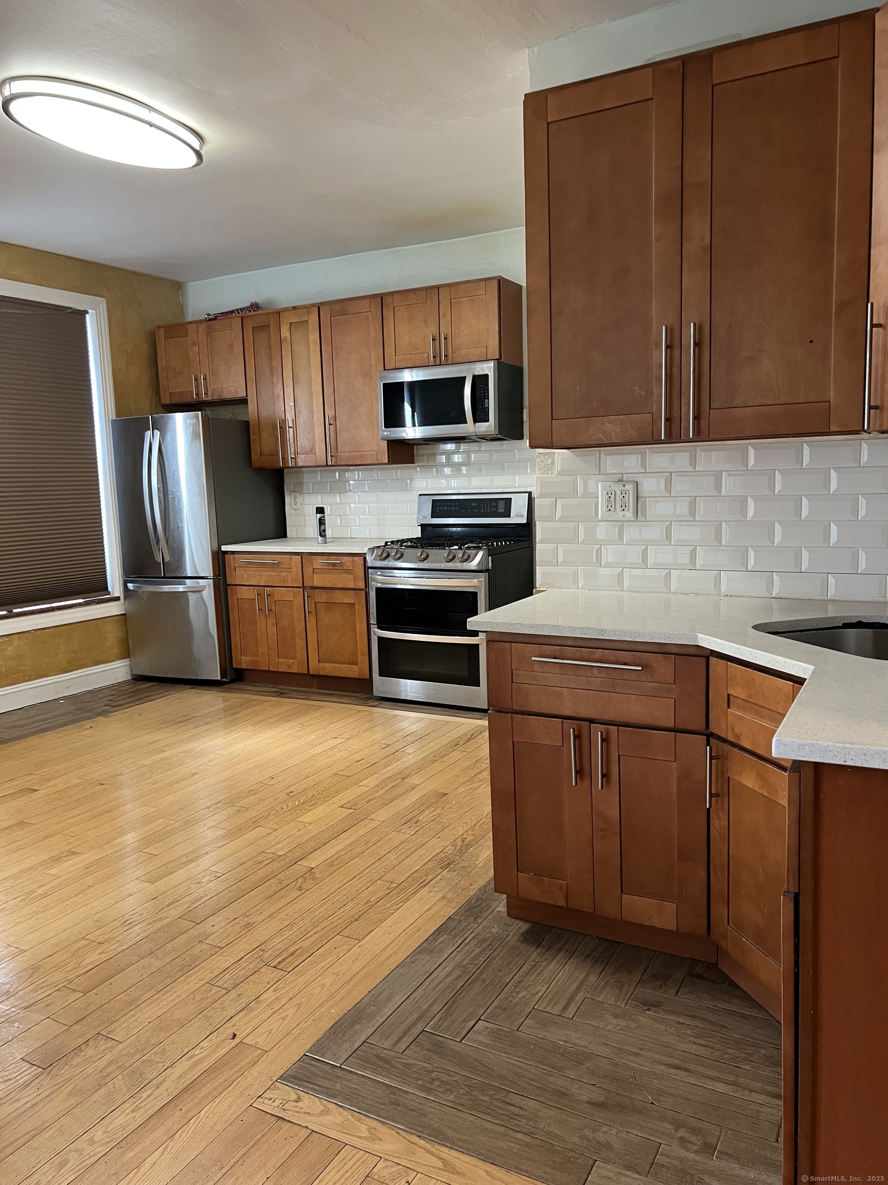546 Congress Avenue, Unit 1 New Haven, CT 06519 - Photo 13 of 14 a kitchen with stainless steel appliances granite countertop a stove top oven a sink dishwasher and a refrigerator with wooden cabinets