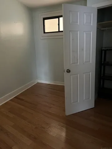 an empty room with wooden floor and closet
