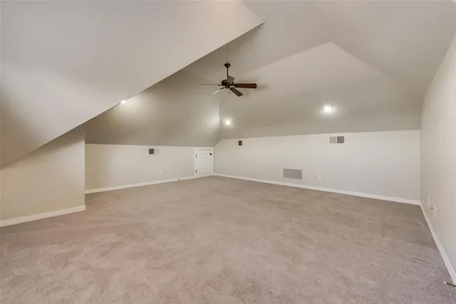 an empty room with a ceiling fan and window