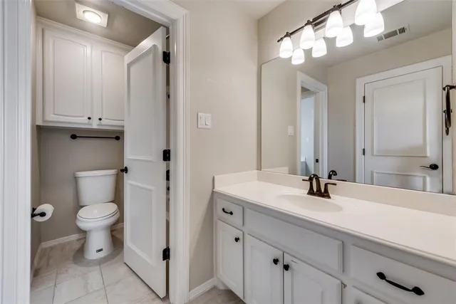 a bathroom with a sink a toilet and a large mirror