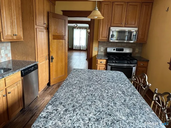 a kitchen with stainless steel appliances granite countertop a refrigerator and a stove top oven