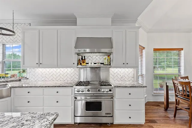 a kitchen with granite countertop a stove a sink and a granite counter tops