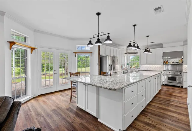 a large kitchen with kitchen island and a large window