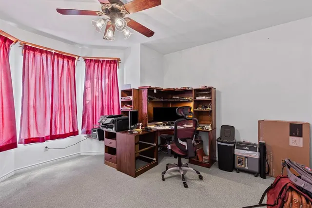 a view of a workspace with furniture and a window