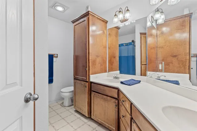 a bathroom with a sink a toilet a mirror and shower