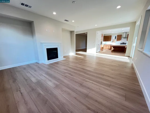 a view of a livingroom with wooden floor and a fireplace