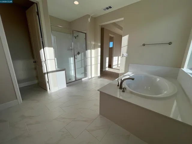 a bathroom with a tub sink and mirror