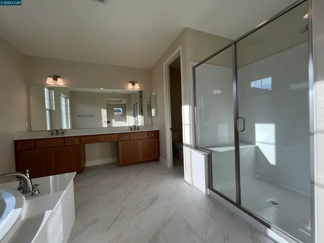 a bathroom with a double vanity sink mirror and shower
