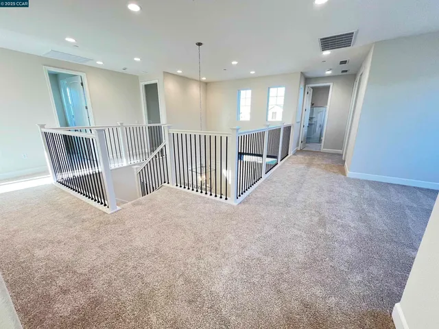 a view of a hallway with a dining table & chairs