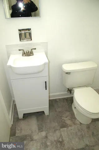 a bathroom with a sink a toilet and mirror