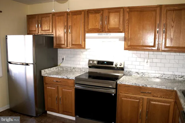 a kitchen with granite countertop stainless steel appliances and wooden cabinets