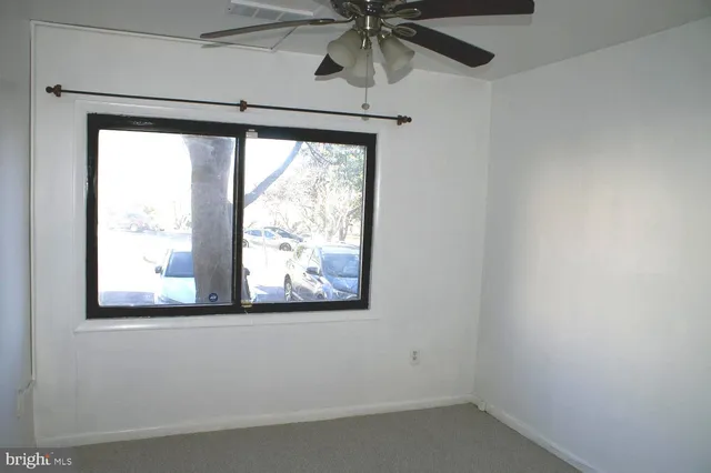 a view of empty room with window and a ceiling fan