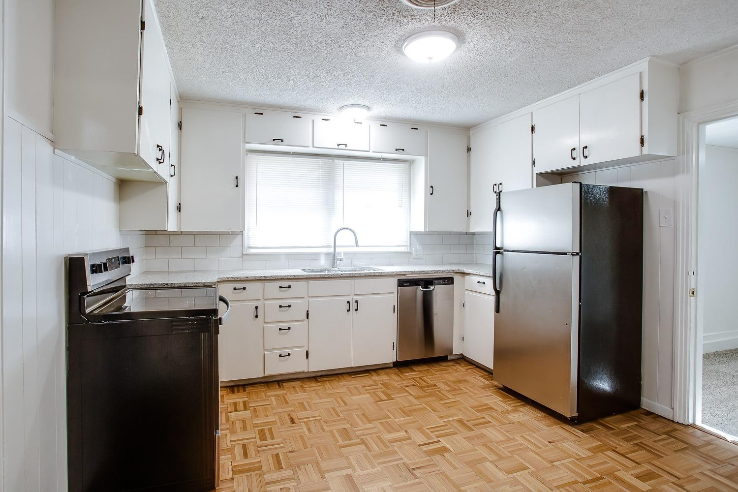 3414 32nd Street Lubbock, TX 79410 - Photo 4 of 11 a kitchen with a refrigerator sink and cabinets