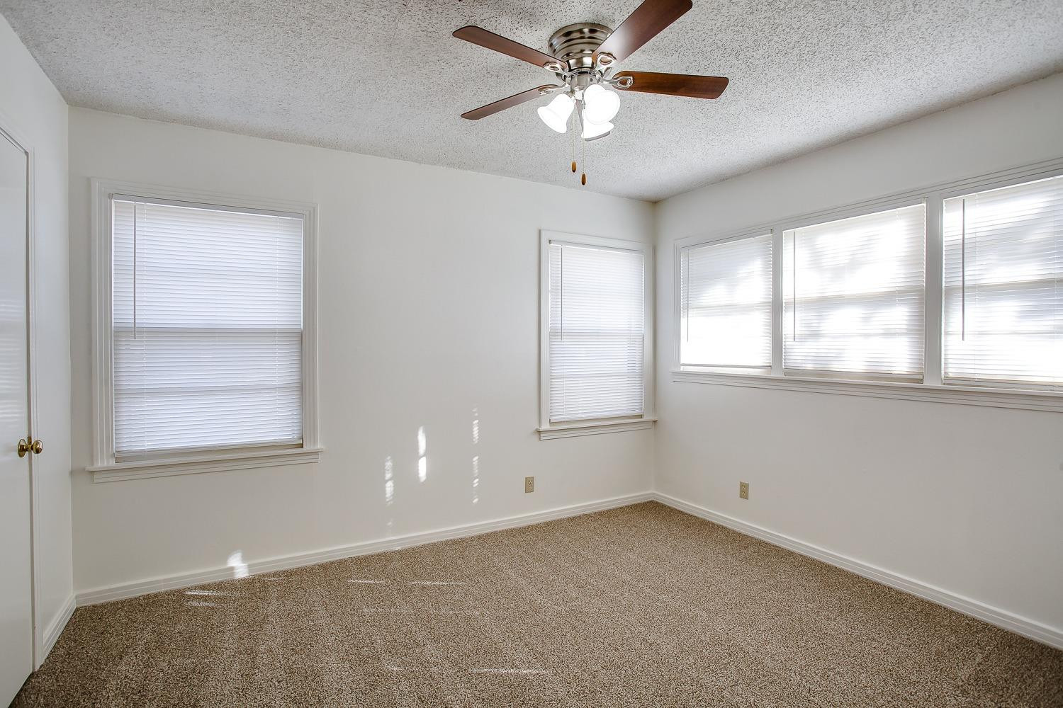 3414 32nd Street Lubbock, TX 79410 - Photo 7 of 11 an empty room with windows and fan